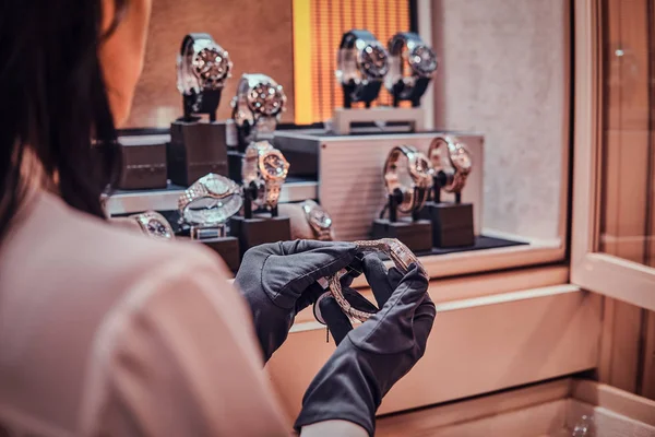 Asistente de tienda está mostrando reloj de oro para un cliente en la joyería —  Fotos de Stock