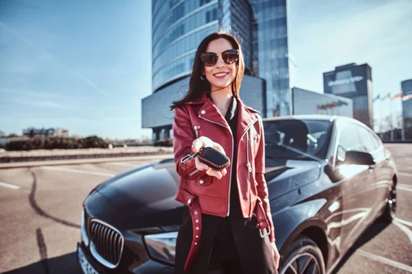 Gelukkig lachende vrouw vasthouden sleutel voor auto, die wordenverbergen haar, zoals dit is de gift voor iemand — Stockfoto