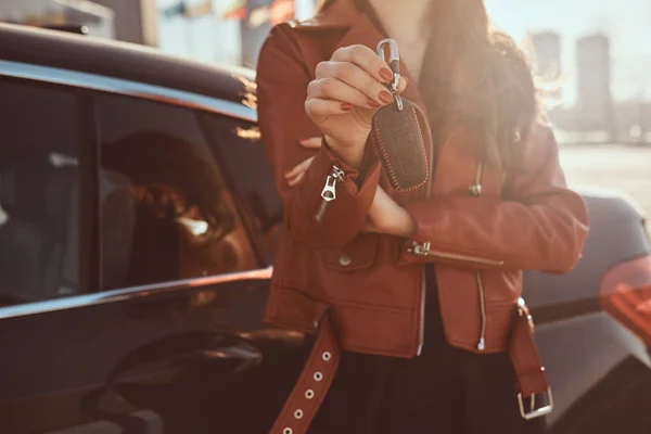 Women in red leather jacket just sold her car, which is behide her — Stock Photo, Image