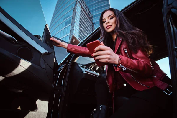 Jeunes femmes attrayantes pose dans sa nouvelle voiture tout en bavardant sur un téléphone mobile — Photo