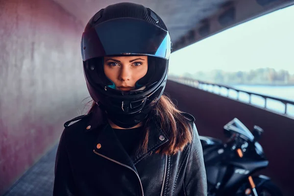 Aantrekkelijke serieuze vrouw staat naast haar Moto Bike — Stockfoto