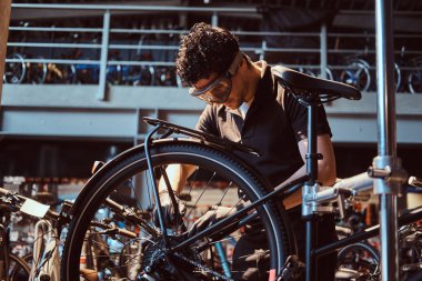 Koruyucu gözlük pensive çalışkan usta atölyede bisiklet sabitleme