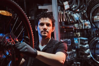 Yakışıklı çalışkan usta işyerinde bisiklet tekerleği sabitleme