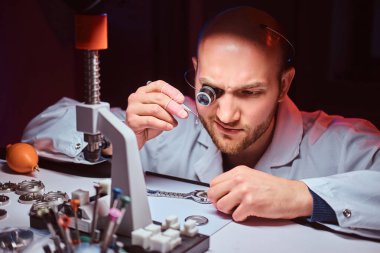 Expirienced saatçi onun atölyesinde custmers izlemek için gravür yapıyor