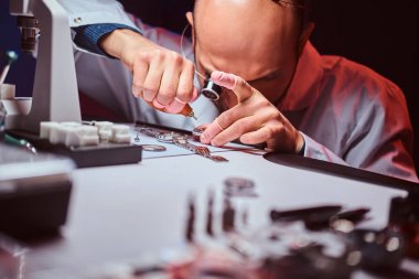 Expirienced saatçi onun atölyesinde custmers izlemek için gravür yapıyor