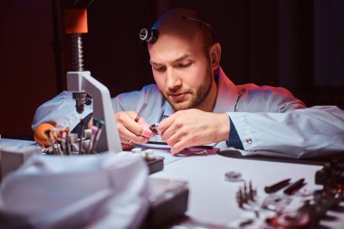 Expirienced saatçi onun atölyesinde custmers izlemek için gravür yapıyor