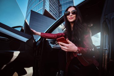 Güzel gülümseyen kadınlar cep telefonu sohbet ederken onu yeni arabada poz