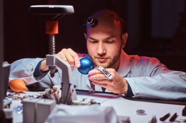Expirienced saatçi onun atölyesinde custmers izlemek için gravür yapıyor