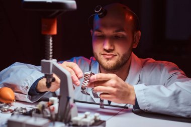 Expirienced saatçi onun atölyesinde custmers izlemek için gravür yapıyor