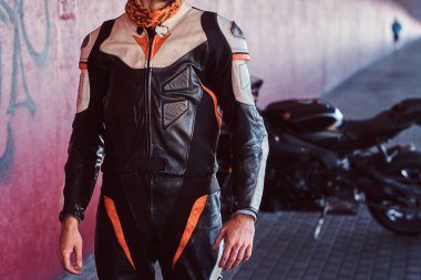 Genç cesur motorcu sessiz tünelde motosikletinin yanında duruyor.