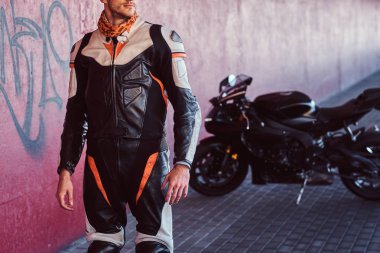 Genç cesur motorcu sessiz tünelde motosikletinin yanında duruyor.
