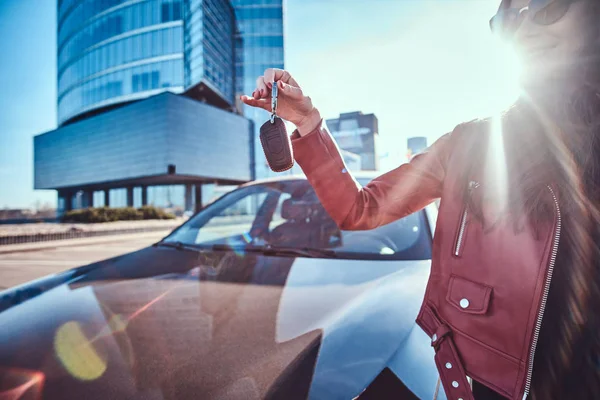 Gelukkige jonge vrouw heeft net sleutels van haar nieuwe auto, die is wordenverbergen — Stockfoto