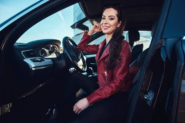 Счастливая молодая женщина сидит в своей новой машине — стоковое фото