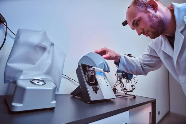 Expirienced watchmaker is doing engraving for custmers watch using special tool at his workshop — Stock Photo, Image