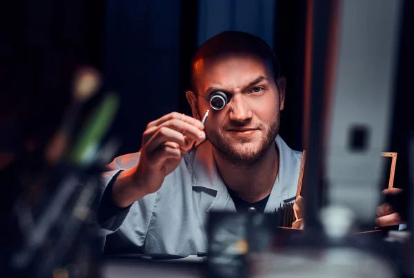 Hombre serio posando para fotógrafo en su lugar de trabajo con monóculo —  Fotos de Stock