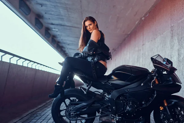 Attractive brave woman is sitting on her motobike in tunnel — Stock Photo, Image