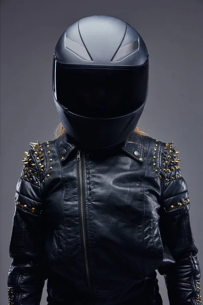 Mode, olahraga, ekstrim. Potret seorang gadis pengendara motor mengenakan kostum pembalap kulit dan helm pelindung di sebuah studio dengan latar belakang abu-abu . — Stok Foto