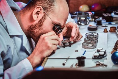 Expirienced clockmaster onun tamir atölyesinde bir müşteri için eski saat sabitleme