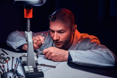 Olgun saatçi kendi stüdyosunda çalışıyor.