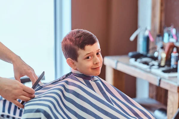 Söta lilla barn blir trendiga frisyr från Barberaren på upptagen barbershop — Stockfoto