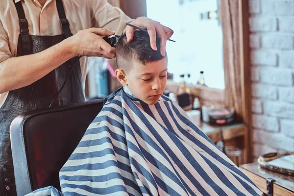 Liten skol pojke blir trendig frisyr från BBW Barber på modern barbershop — Stockfoto