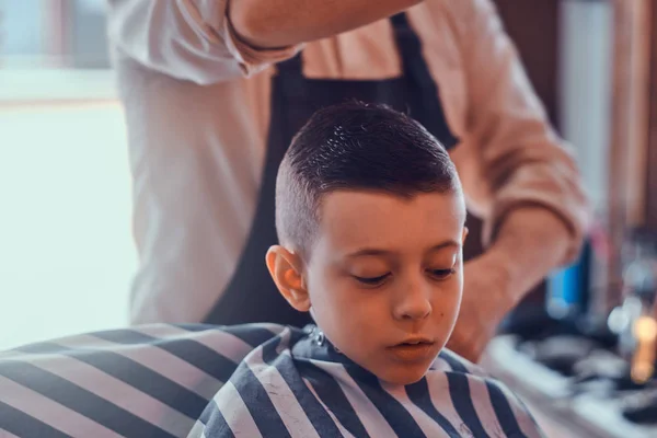 Little pretty school boy had his first trendy haircut at modern barbershop — Stock Photo, Image