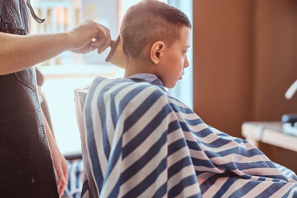 Menino da escola calma está se preparando para a escola na barbearia da moda — Fotografia de Stock