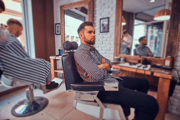 Çekici dalgın adam meşgul berber dükkanında bir saç kesimi almak için sırasını bekliyor — Stok fotoğraf