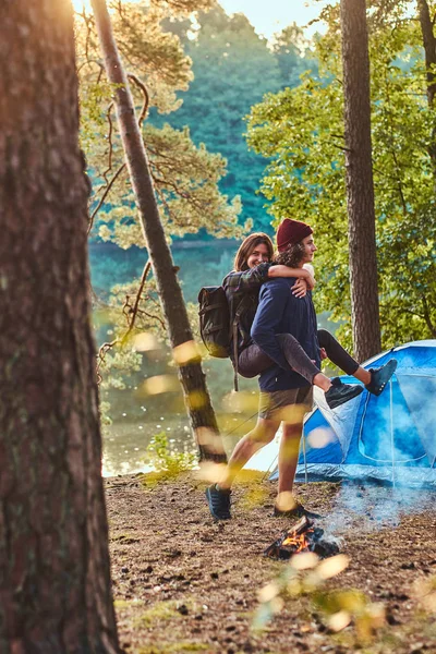 Fiatal romantikus pár szórakozni a nyári erdőben, közel a sátor — Stock Fotó