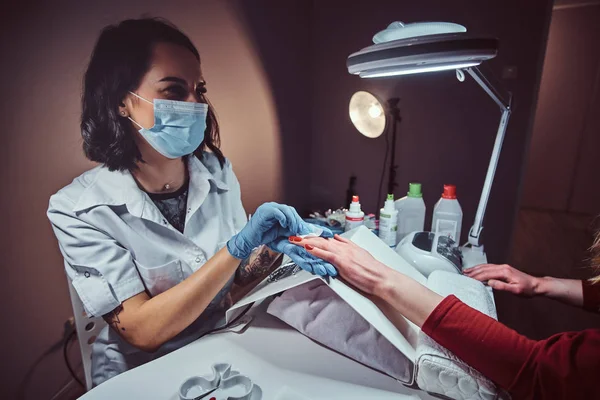 Schoonheidsspecialiste meester poetsen klanten nagels na manicure proces in de schoonheidssalon — Stockfoto