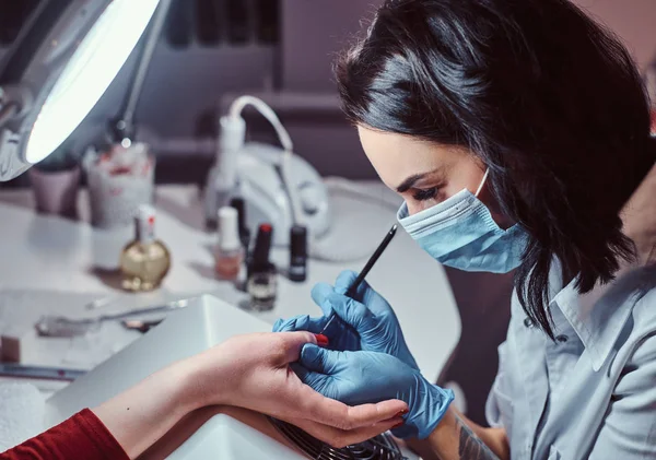 Kosmetyczka praca z klientem w salonie piękności, stosowanie kolorowego lakieru do paznokci. — Zdjęcie stockowe