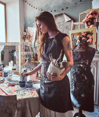 Atölyede yetenekli sanatçı fırçalar ile kavanoz tutarken yeni projesi için boya karıştırma