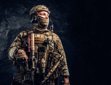 Modern Özel Kuvvetler asker kamuflaj üniforma yana doğru bakarak. Karanlık bir duvara Studio fotoğraf.