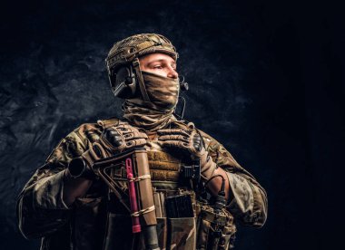 Modern Özel Kuvvetler asker kamuflaj üniforma yana doğru bakarak. Karanlık bir duvara Studio fotoğraf.