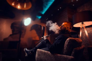 Zarif akıllı adam rahatlatıcı ve uzun zor bir günün ardından nargile sigara