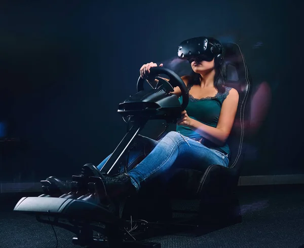 Vrouw met Vr-headset op autoracesimulator cockpit met stoel en wiel. — Stockfoto