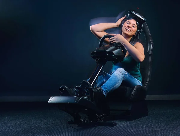 Mulher feliz vestindo fone de ouvido VR e sentado no simulador de corrida . — Fotografia de Stock