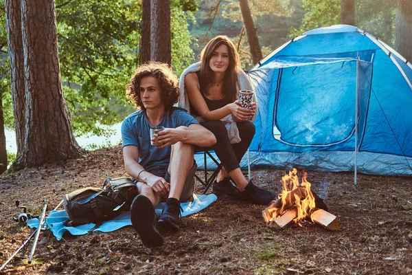 Attractive young couple have a rest in summer forest