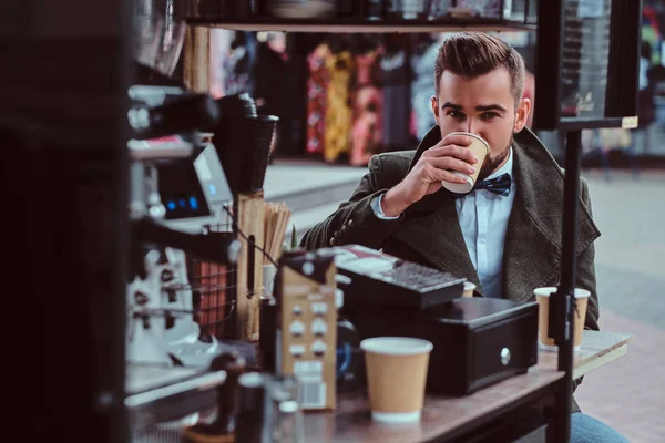 Elegante hombre está disfrutando de su café mientras está sentado afuera en coffeeshop . — Foto de Stock