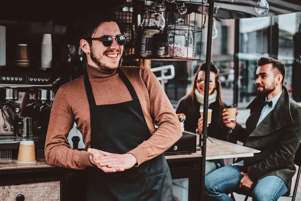 Atractivo barista alegre en gafas de sol tomó un café en su propio coffeeshop —  Fotos de Stock