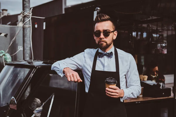 Inteligente barista en vasos tiene un descanso en su propio coffeeshop . — Foto de Stock