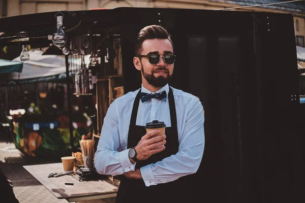 Inteligente barista en vasos tiene un descanso en su propio coffeeshop . — Foto de Stock