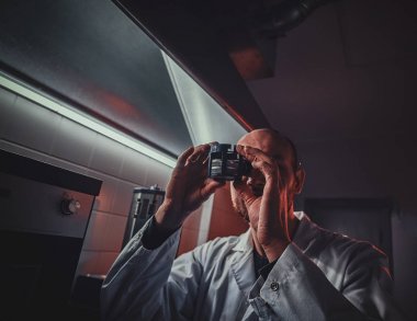 Odaklanmış saatçi kendi stüdyosunda otoklav ile çalışıyor