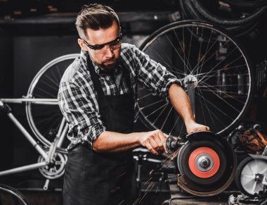 Repairmaster meşgul bucycle atölyesinde takım tezgahı ile çalışıyor.