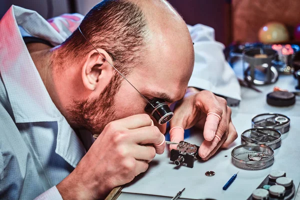 Routinierter Uhrmacher repariert alte Uhr für einen Kunden in seiner Werkstatt — Stockfoto