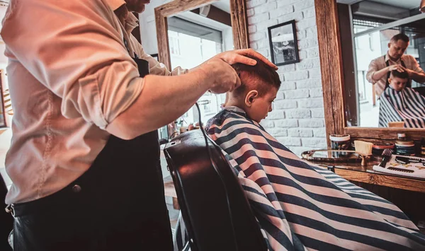 Sevimli küçük çocuk meşgul berber de berber moda saç kesimi oluyor — Stok fotoğraf