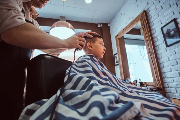 Sevimli küçük çocuk meşgul berber de berber moda saç kesimi oluyor — Stok fotoğraf