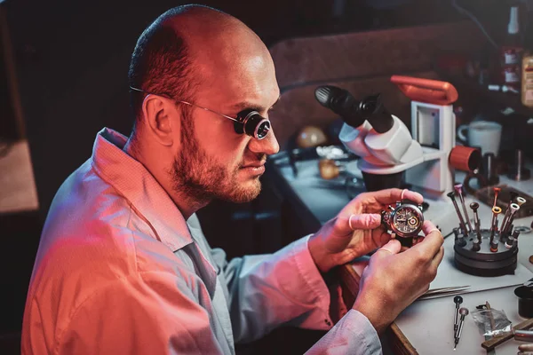 Serious watchmaker  is repairing cutomers order at his own repairing studio — Stock Photo, Image