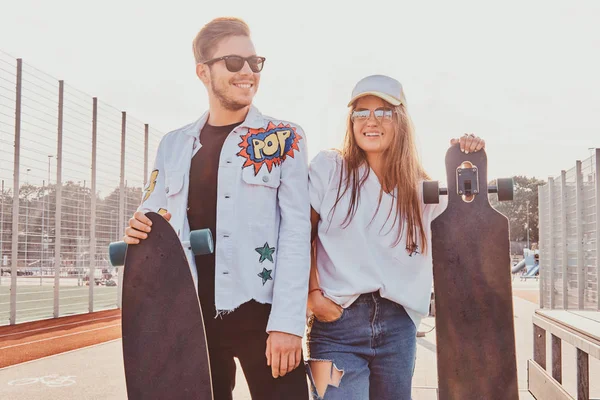 Lyckligt leende par står på sommar gatan med sina Longboards — Stockfoto