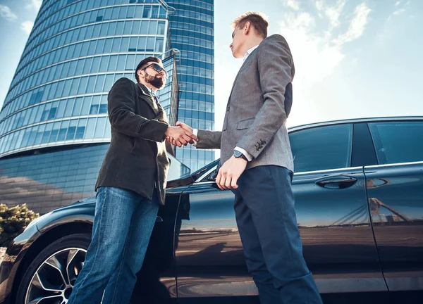 Foto de baixo ângulo de dois homens elegantes inteligentes, que têm um acordo sobre o carro — Fotografia de Stock